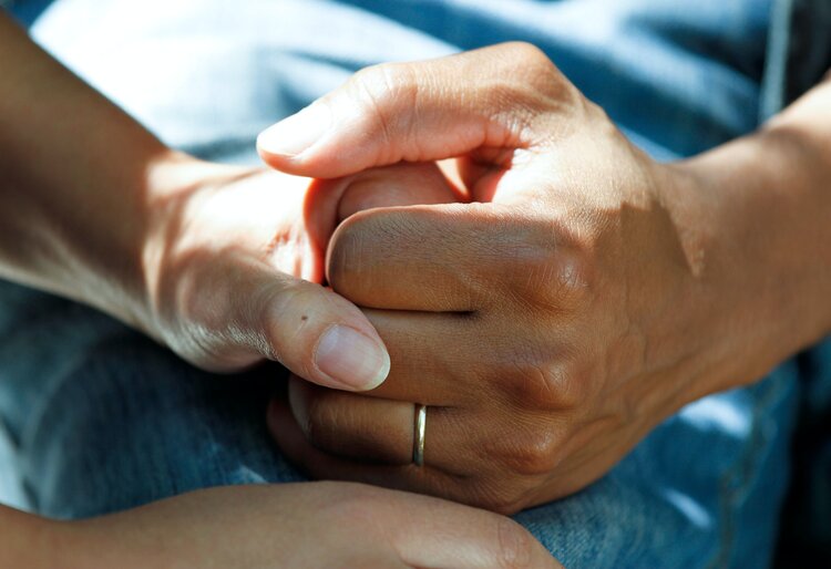 Image of two people holding hands as one suffers from a medical condition